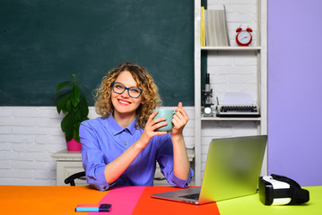 Beautiful teacher in classroom. Female teacher near blackboard. Young smiling female student studying in school. Happy student or woman teacher. Exam in college. University student going to college.