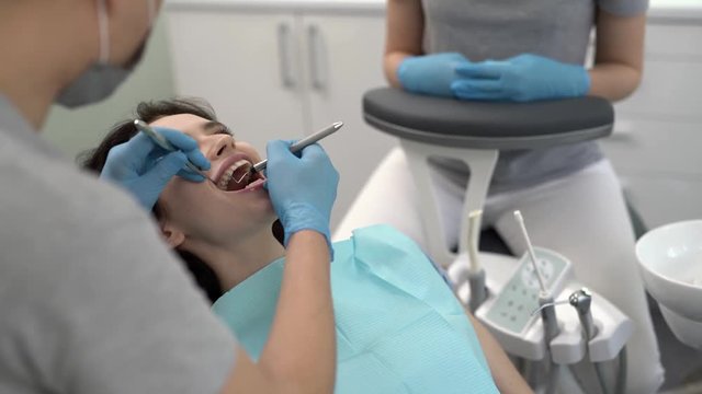 Pretty woman's teeth treatment in dental clinic