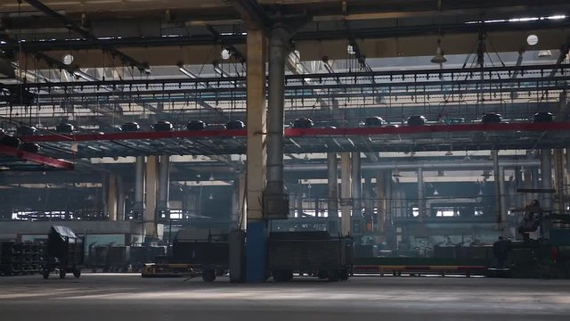 Conveyor with tires at factory. Tyres production. Moving conveyor transfers formed rubber tires along large manufacturing plant workshop. Manufacture of tires. Tyre production machine conveyor.