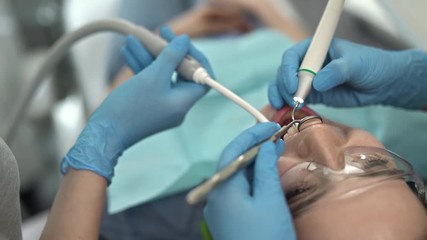 Pretty woman's teeth treatment in dental clinic