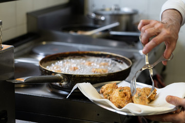 Cod fish fritters being fried in kitchen
