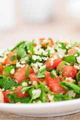 Fresh vegan Tabbouleh salad made of tomato, parsley, onion and couscous on plate (Selective Focus, Focus in the middle of the image)