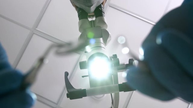 Doctor is using dental microscope during his work