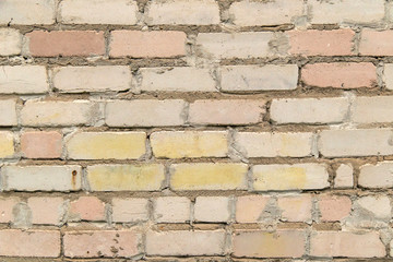 textured, expressive wall of light-colored bricks