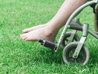 Fototapeta na wymiar Paralyzed man using wheelchair during walk in park.