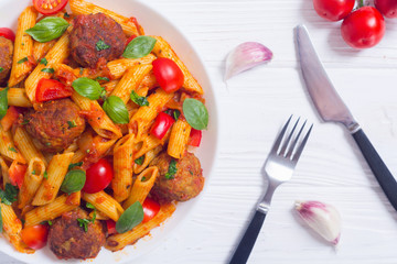 Italian penne pasta with meatballs and tomatoes
