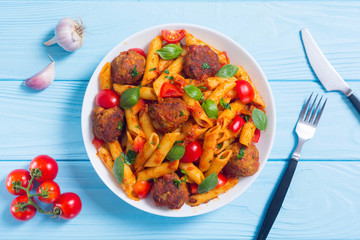 Italian penne pasta with meatballs and tomatoes