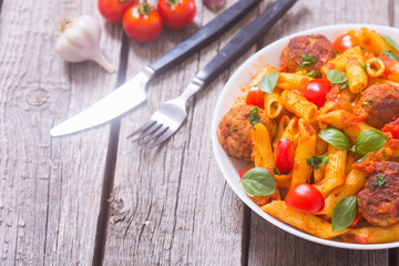 Italian penne pasta with meatballs and tomatoes