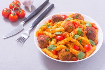 Italian penne pasta with meatballs and tomatoes
