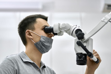 Dentist is using dental microscope during his work