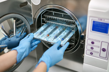 Dentist is loading dental probes into sterilize machine
