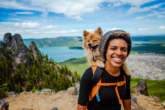 Girl hiking with dog in backpack