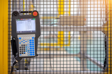 Automation concept: View of robot control panel hang on machine fence