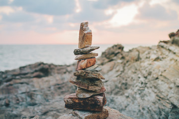 A stack of round stones standing on the shore of a sea Rocky coast at Khao Laem Ya Mu Ko Samet National Park Rayong, Thailand in sunset time