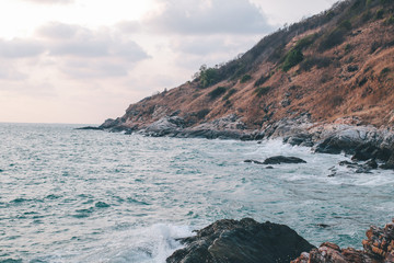 Danger sea wave crashing on rock coast with spray and foam at Khao Laem Ya Mu Ko Samet National Park Rayong, Thailand in sunset time