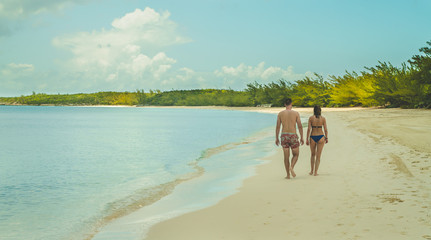 Young Couple walking on the sandy Beach Half moon Cay 