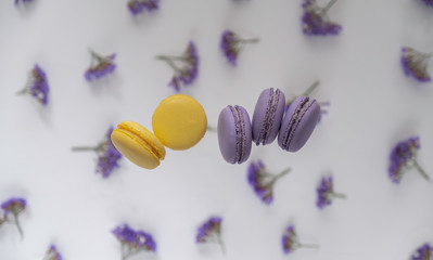 Traditional French purple, yellow macaroons on a flower background.