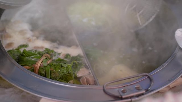 Indonesian street food, cooking mie ayam on boiled hot water
