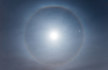 Beautiful Moon halo phenomenon in the starry night sky. The halo is caused by ice crystals in the...