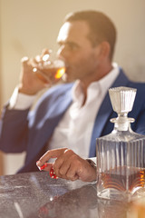 Alcoholism is an equal opportunity destroyer. An elegant man suffering from alcoholism and gambling