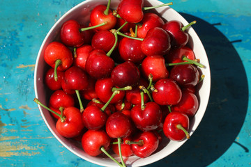 cherries in a bowl on blue wooden background