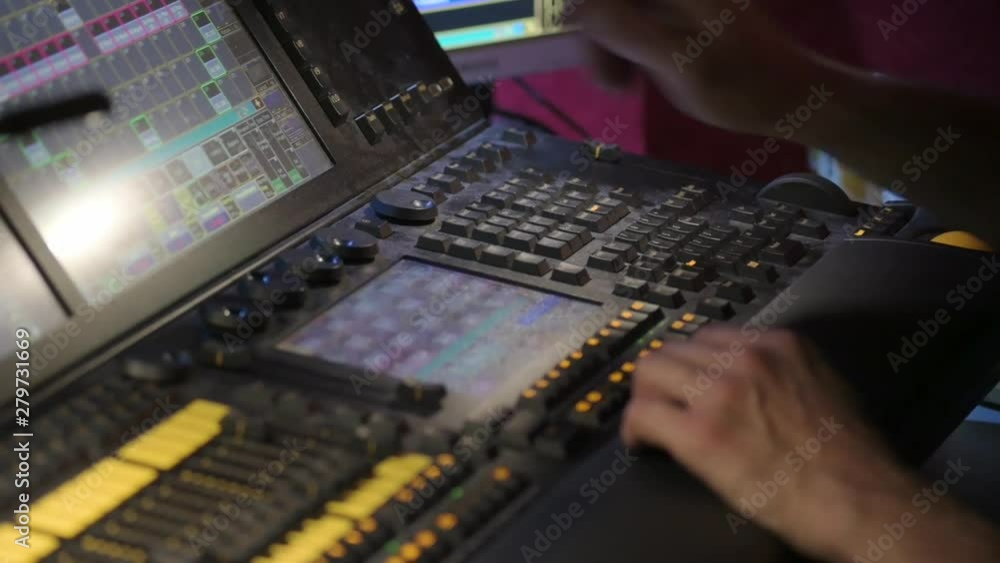 Poster hands using a control panel in a control room, during a live event. close up.
