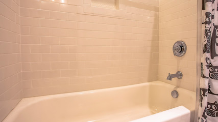 Panorama Bathtub and shower inside a bathroom with glossy white wall