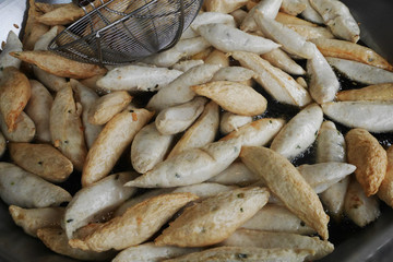 deep fried fish ball in boiled oil on a pan in kitchen stove.