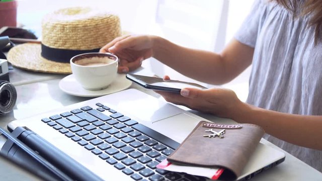 Young traveler planning vacation trip and searching information or booking hotel on laptop and smartphone, Travel concept