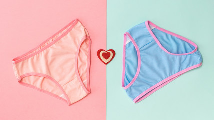 Blue and pink panties and heart on a pink and blue background. The concept of meeting lovers....
