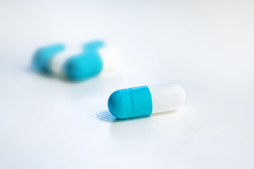 several blue capsules close-up on a white background