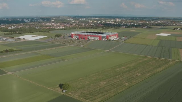 Drone / Aerial shot of the football stadium of the bundesliga team FSV Mainz 05 with field in the foreground on a sunny day, 25p