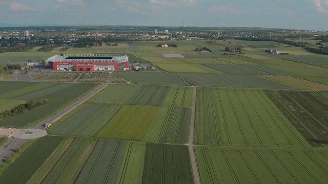 Drone / Aerial shot of the football stadium of the bundesliga team FSV Mainz 05 with field in the foreground on a sunny day, 30p