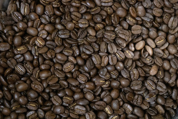 Coffee beans background.Brown roasted coffee beans pattern in coffee shop prepared for making cappuccino or latte hot drink.