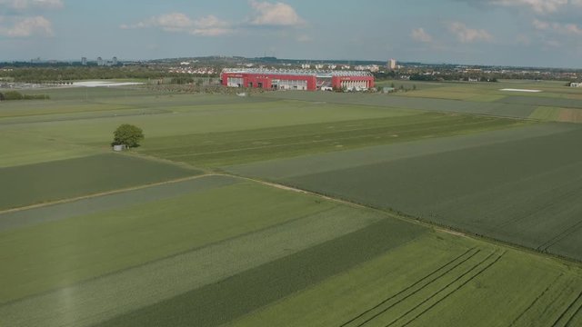 Drone / Aerial shot of the football stadium of the bundesliga team Mainz 05 with field in the foreground on a sunny day, 30p