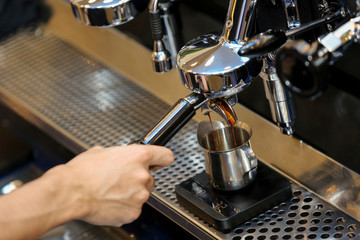 Fototapeta na wymiar Espresso pouring from coffee machine