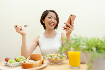 スマートフォンを見ている笑顔の女性