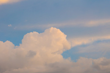 The clouds touched by the yellow light in the sky in the afternoon light before sunset. 