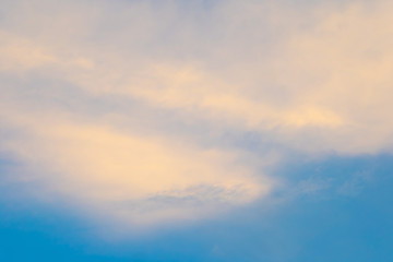 The clouds touched by the yellow light in the sky in the afternoon light before sunset. 