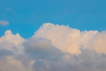 The clouds touched by the yellow light in the sky in the afternoon light before sunset. 