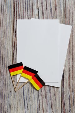 October 3, happy Day of German unity. the concept of patriotism , freedom and independence. Mini flags with a white card on wooden background