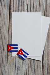 Fototapeta na wymiar October 10, happy independence Day of Cuba. the concept of patriotism , freedom and independence. Mini flags with a white card on wooden background