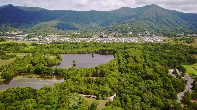 Aerial footage of Cattana Wetlands, urban area of Smithfield, and forested mountains near Cairns, Queensland, Australia. August 2018.