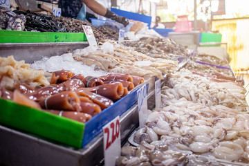 The fresh seafood such as fish squid shell on the shelfs to sell in the fresh market. The number in the picture is the price in Thai Baht per kiligram. 