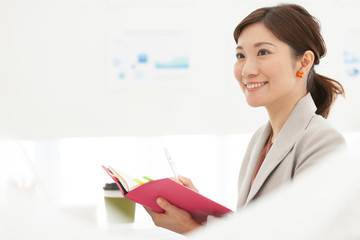 手帳を持っている笑顔のビジネスウーマン