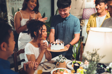Asian friends group Celebrating at a birthday party She is blowing candles