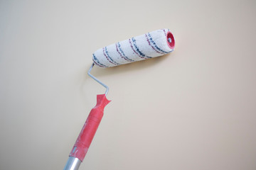 roller paint stands against the wall, painting the walls. background