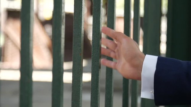 Man in blue suits hands moving along green bars train station