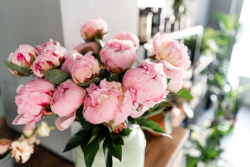 The counter of the flower shop. Pink peonies in a metal vase. Beautiful peony flower for catalog or online store. Floral shop concept . Beautiful fresh cut bouquet. Flowers delivery