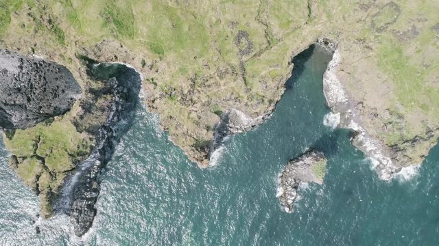 Majestic 4K bird's-eye view aerial of the turquoise North Atlantic ocean and seagulls flying next to the cliffs of Hellnar and Arnarstapi, both popular tourist attraction on the west coast of Iceland.